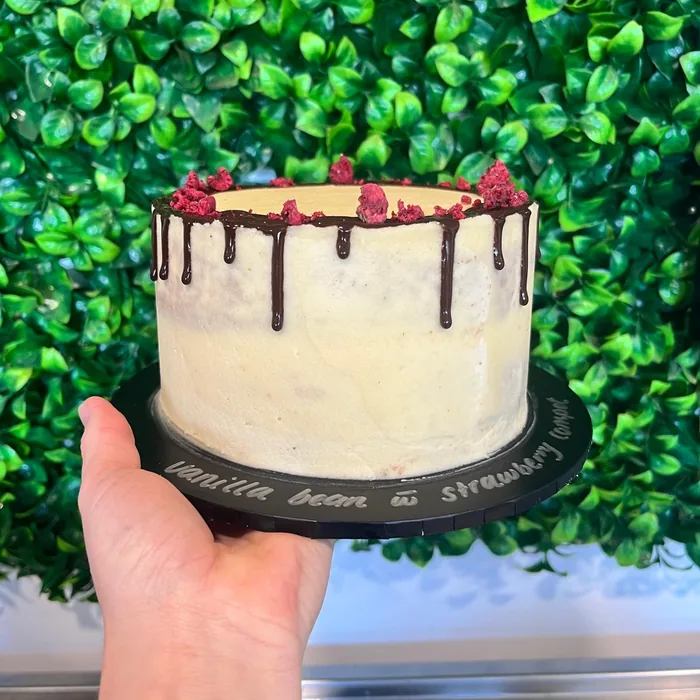 White buttercream drip cake topped with a strawberry