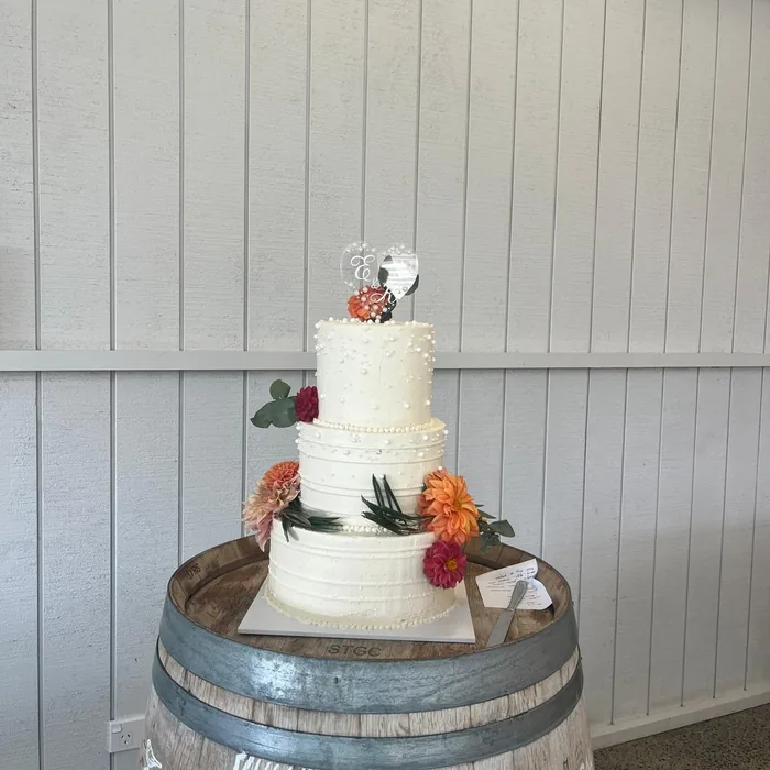 Tiered white wedding cake with fresh flowers