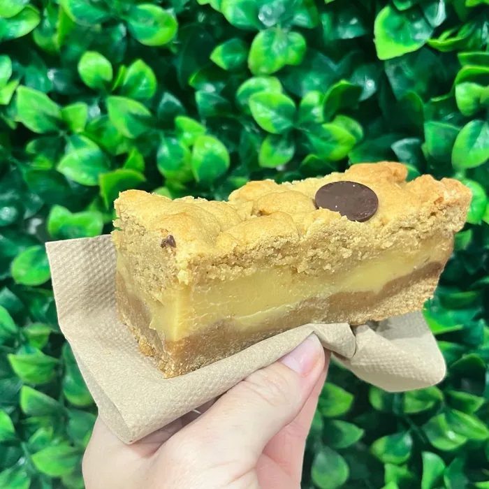 Slice of caramel bakery slice held up
