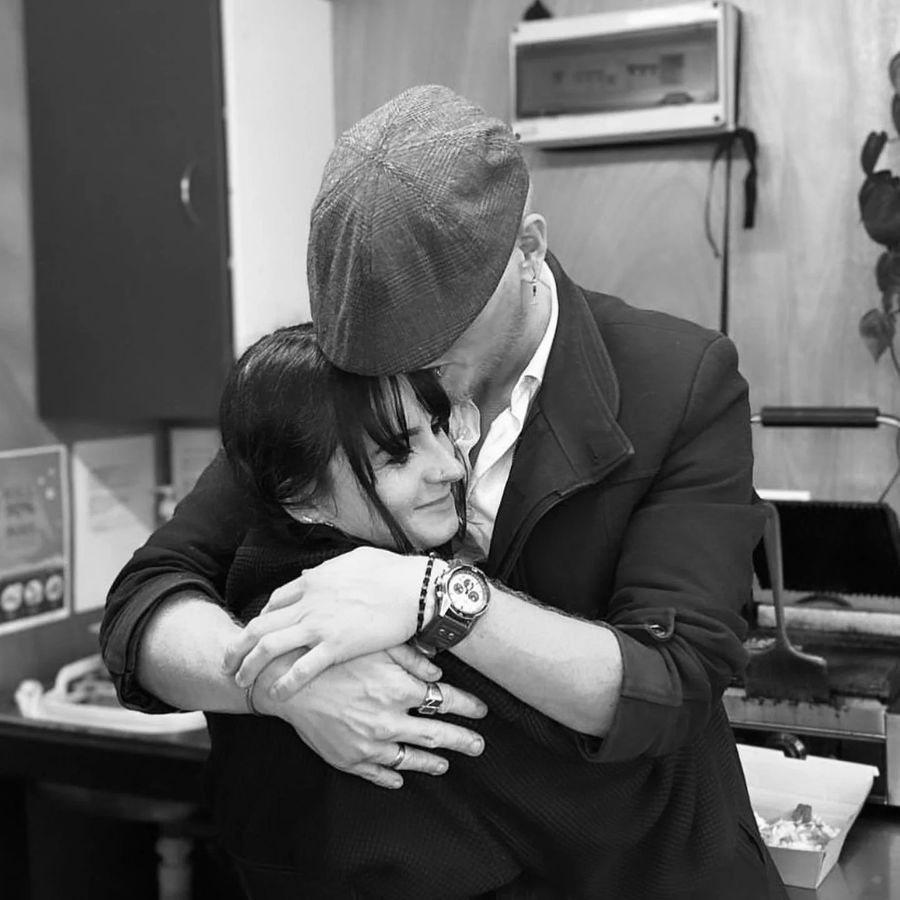 Jess and Damion, the couple who own Mini Misfits Cafe, sharing a hug behind the counter