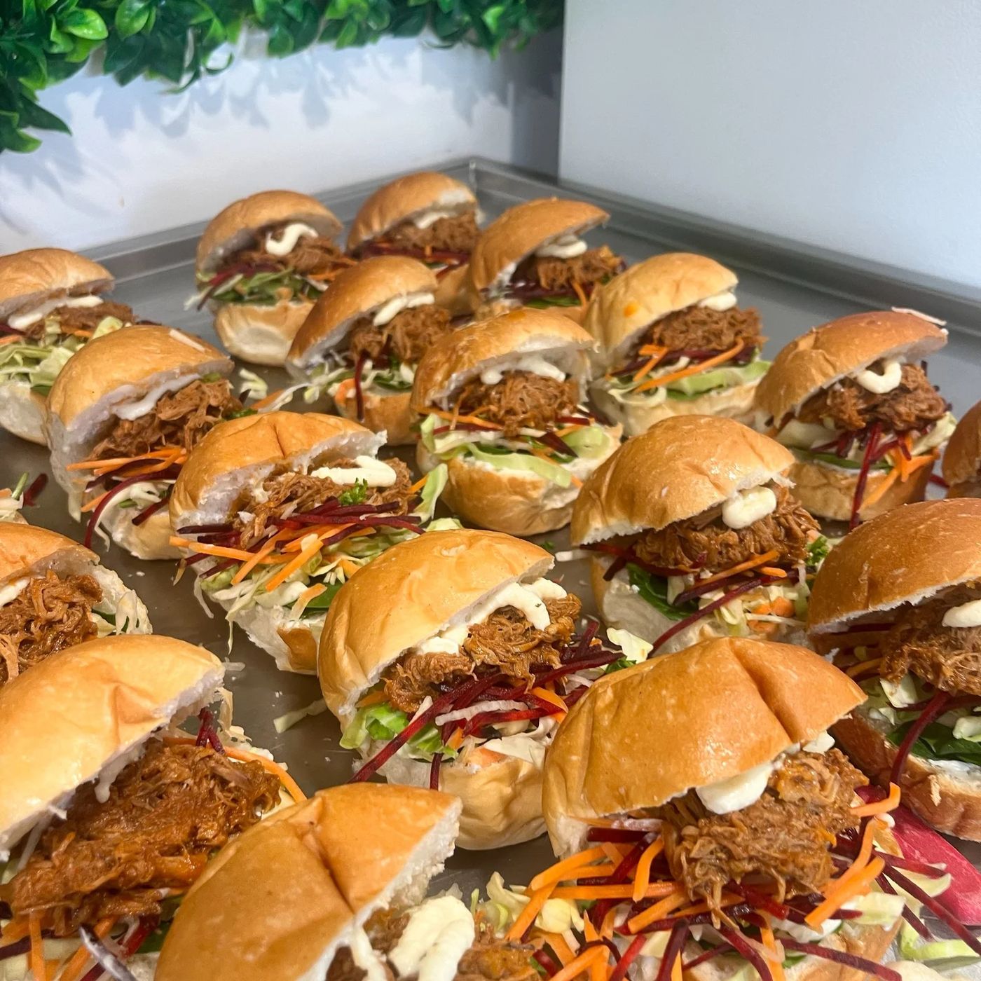 Tray of pulled pork sliders with fresh slaw prepared for event catering