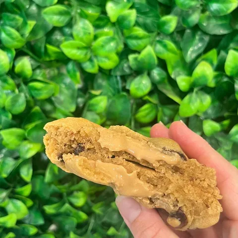 Peanut butter stuffed cookie held up, showing the soft centre